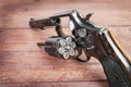 Black revolver gun with bullets on wooden background Royalty Free Stock Photo