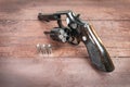 Black revolver gun with bullets on wooden background Royalty Free Stock Photo