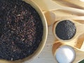 Black rice, black sesame, sugar, in a wooden dish, placed on a wooden tray. Royalty Free Stock Photo