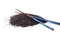 Black rice grains pile with chopsticks isolated Royalty Free Stock Photo