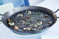 Black rice paella with seafood and fish. Traditional Spanish recipe. Royalty Free Stock Photo