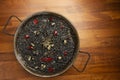 Black rice with squid in paella pan on wooden background Royalty Free Stock Photo
