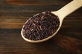 Black rice in a wooden spoon