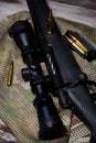 The Black Rifle with ammo and scope on the multicam background. Close up