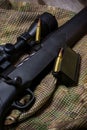 The Black Rifle with ammo and scope on the multicam background. Close up