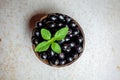 Black ripe Syzygium cumini fruits. Dark black java plum in a wood bowl at isolated white background. Green mint leaf on top of Royalty Free Stock Photo