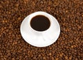 Black roasted arabica coffee beans and cup full of coffee Royalty Free Stock Photo