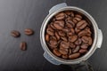 Black roasted coffee beans and a coffee machine flask. Accessories for brewing coffee on a black kitchen table Royalty Free Stock Photo