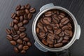 Black roasted coffee beans and a coffee machine flask. Accessories for brewing coffee on a black kitchen table Royalty Free Stock Photo