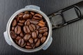 Black roasted coffee beans and a coffee machine flask. Accessories for brewing coffee on a black kitchen table Royalty Free Stock Photo