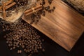 Black roasted coffee grains and cinnamon. On a wood background. Top view and frame for inscriptions.