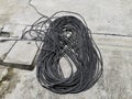 Black rolled electric cable on a road surface background Royalty Free Stock Photo