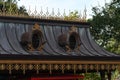 Black roof of a building with golden decorations and ellipse-shaped windows