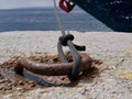 A black rope made of synthetic material holds the yacht at the pier against the background of the sea on a sunny summer day. The Royalty Free Stock Photo