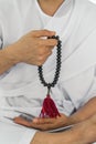 Black rosary beads in hand of religious buddhist man in white clothing having sitting and rosary count meditation Royalty Free Stock Photo