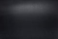 Black, rough textured background lit with dim light. Royalty Free Stock Photo