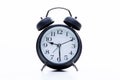 Black round metallic retro alarm clock isolated on white background. The clock shows daytime working hours