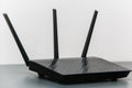 Black router with three antennas in white background