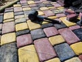 A black rubber hammer lies on the surface of motley colored paving slabs Royalty Free Stock Photo