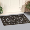 Black Rubber Scraper Floor Mat Indoor Outdoor door mat outside home with yellow flowers and leaves Royalty Free Stock Photo