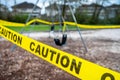 Black rubber swings in closed public playground surrounded by yellow caution tape during Corvid-19 Coronavirus pandemic Royalty Free Stock Photo