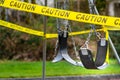 Black rubber swings in closed public playground surrounded by yellow caution tape during Corvid-19 Coronavirus pandemic Royalty Free Stock Photo