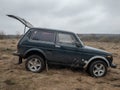 Black Russian off-road car Lada Niva 4x4 VAZ 2121 / 21214 parked on the field.