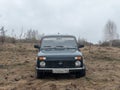 Black Russian off-road car Lada Niva 4x4 VAZ 2121 / 21214 parked on the field.