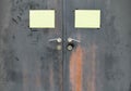 Black rusty iron door with handle and yellow paper attached Royalty Free Stock Photo