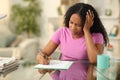 Black sad woman signing form at home