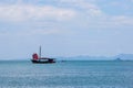 Black sailing ship with red sails sailing on the blue sea