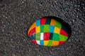 Painted stone with many colors in the black sand of the beach.