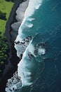 A black sand beach with green trees and lava flowing in the back