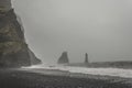 Black sand beach Reynisfjara, Iceland during foggy weather, mountain range with sea and beach in front Royalty Free Stock Photo