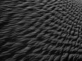 Black Sand dune. Black Sand beach macro photography. Background, texture, wave pattern of oceanic sand on the beach, black. Textur Royalty Free Stock Photo