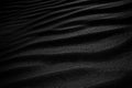 Black Sand dune. Black Sand beach macro photography. Background, texture, wave pattern of oceanic sand on the beach, black. Textur