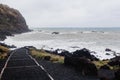Black sand volcanic beach with white sea foam in Azores Islands. Royalty Free Stock Photo