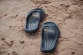 Black sandals on the beach sand Royalty Free Stock Photo