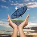 Black Satellite dish in hand of businessman on sunset background Royalty Free Stock Photo