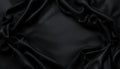 Black satin fabric with smooth texture and subtle sheen. The fabric is draped and wrinkled, creating a luxurious Royalty Free Stock Photo