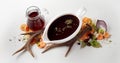 Black sauce in oval bowl and vinegar carafe placed on table near scattered veggies