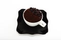 Black saucer and cup with coffee beans and ground coffee Royalty Free Stock Photo
