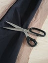 Black scissors with black and cream fabric on the foor