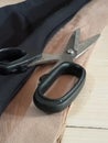 Black scissors with black and cream fabric on the foor