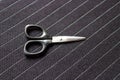 Black scissors on striped dark fabric background - Image