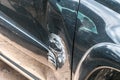 Black scratched car with damaged paint in crash accident on the street or collision on parking lot in the city with dented doors