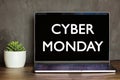 black screen laptop front view on office table with text cyber monday, succulent plant in pot on wooden desk. Designer workspace. Royalty Free Stock Photo