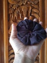 Black scrunchie with balinese carved wood as background