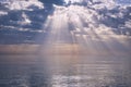 The Black Sea in the evening with the setting sun. Godrays come from the bright clouds illuminating the scene. Seaside landscapes