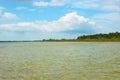 Black Sea foreland landscape. Green water surface, forest on horizont line and blue sky with clouds. Royalty Free Stock Photo